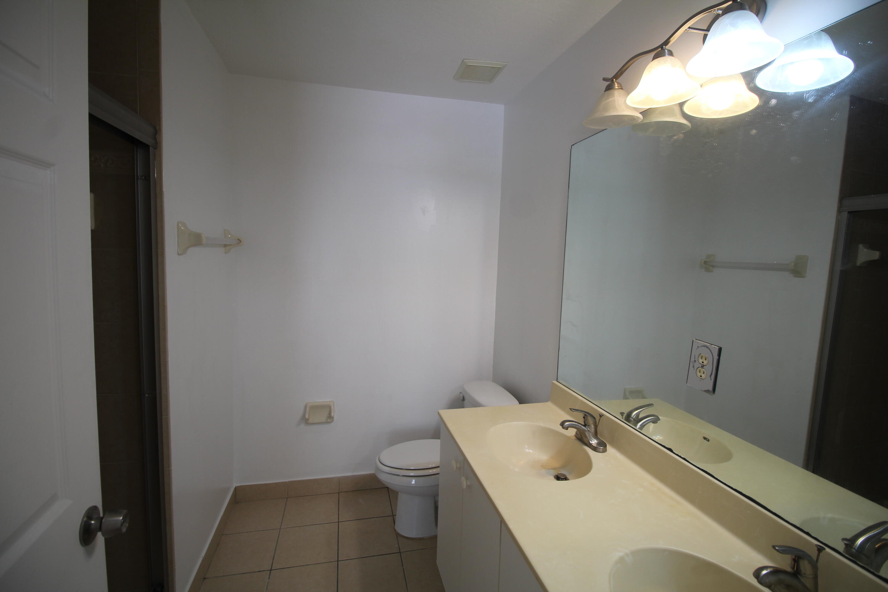 6375 Landings Way, Unit 6375 Tamarac, FL 33321 - Photo 9 of 14 a bathroom with a sink a toilet and a mirror