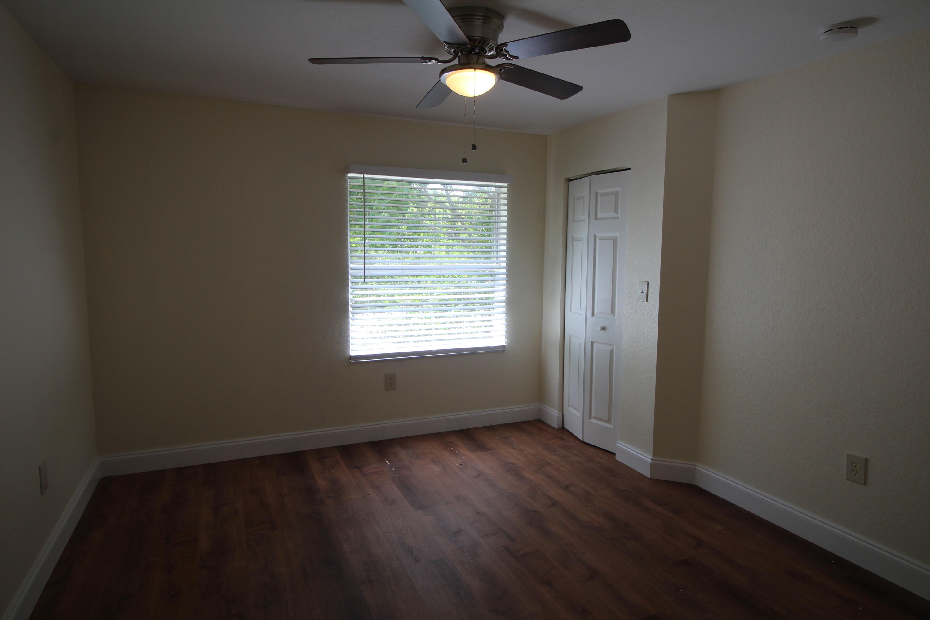 6375 Landings Way, Unit 6375 Tamarac, FL 33321 - Photo 10 of 14 an empty room with wooden floor fan and windows