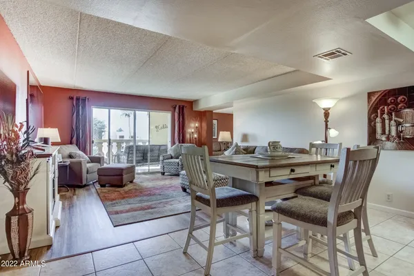 a living room with furniture a rug potted plant and a large window