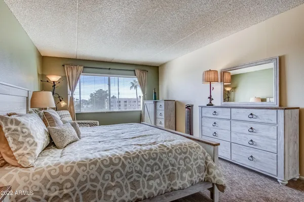 a bedroom with a large bed and a dresser