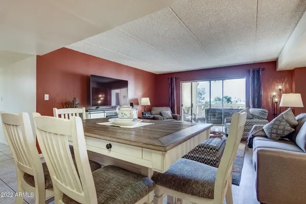 a view of living room and kitchen with furniture and large windows