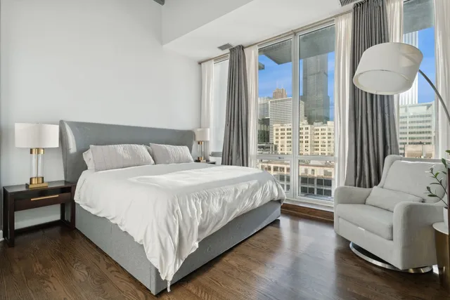 a bedroom with a bed and a flat tv screen on the dresser