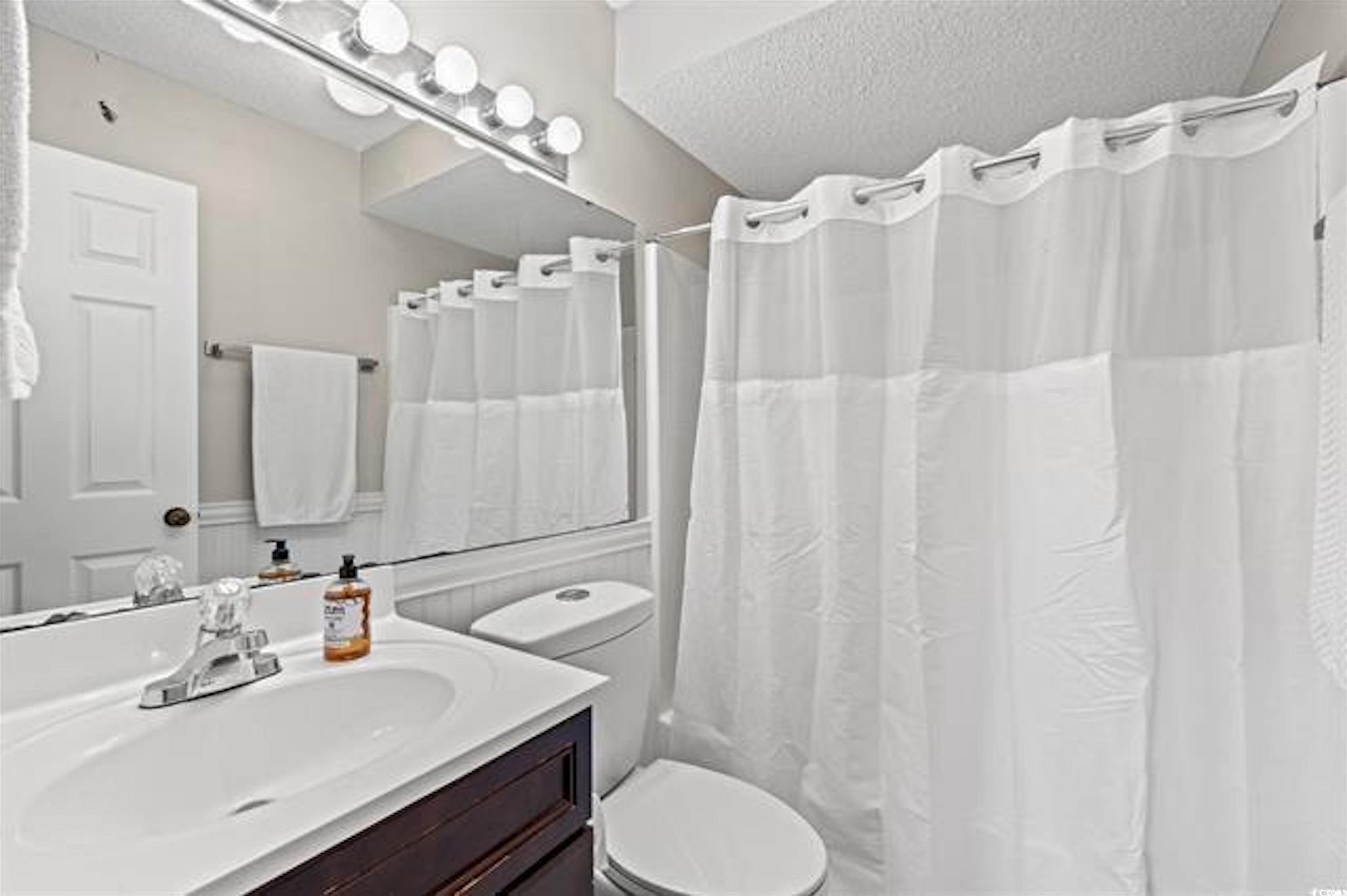 1100 Possum Trot Road, Unit B206 North Myrtle Beach, SC 29582 - Photo 12 of 16 Bathroom with toilet, vanity, curtained shower, an