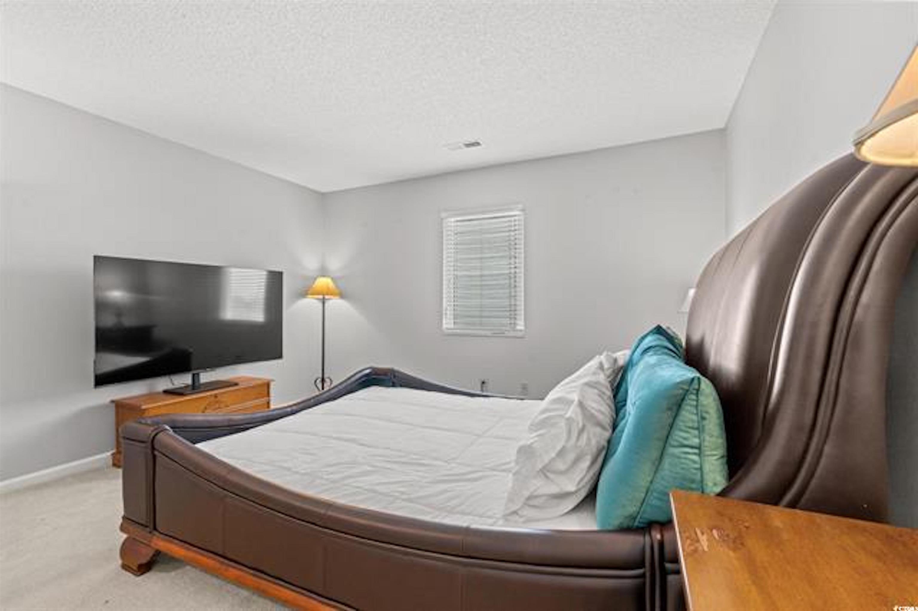1100 Possum Trot Road, Unit B206 North Myrtle Beach, SC 29582 - Photo 15 of 16 Carpeted bedroom with baseboards and a textured ce