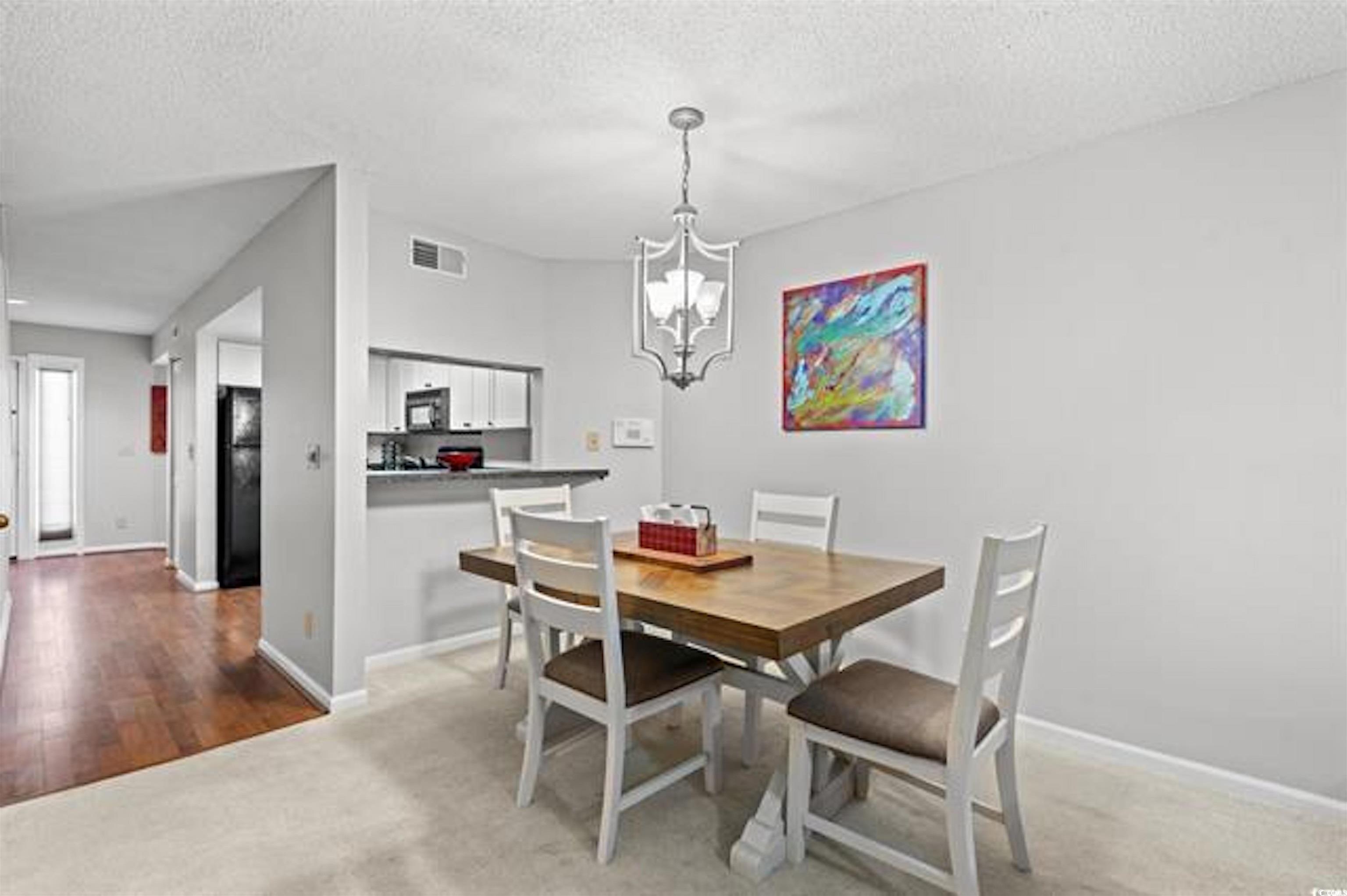 1100 Possum Trot Road, Unit B206 North Myrtle Beach, SC 29582 - Photo 5 of 16 Dining area with baseboards, a textured ceiling, v