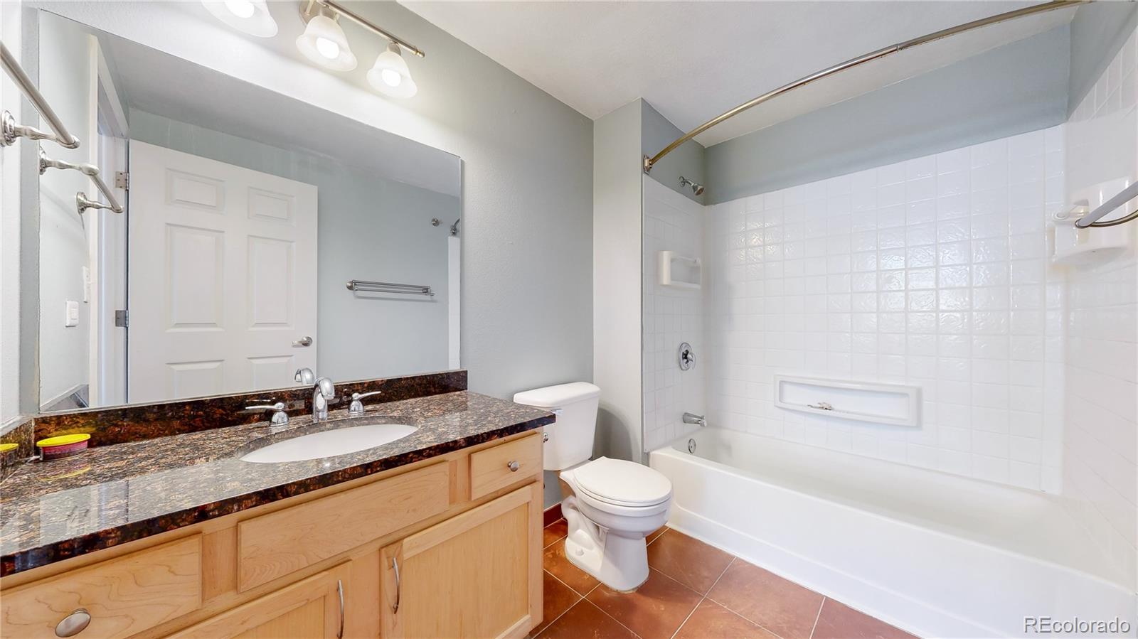 444 17th Street, Unit 301 Denver, CO 80202 - Photo 11 of 21 a bathroom with a granite countertop sink a toilet and shower