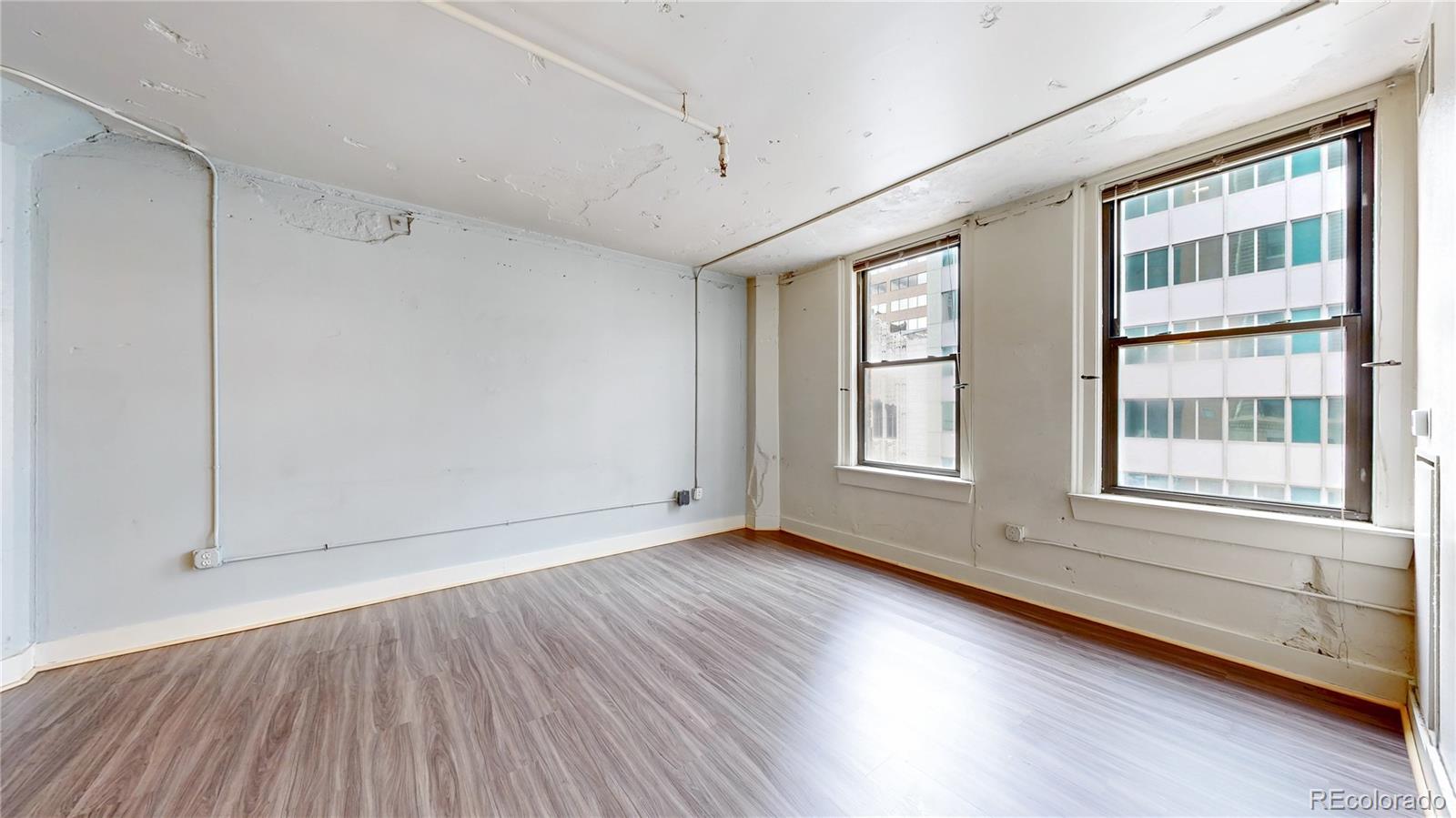 444 17th Street, Unit 301 Denver, CO 80202 - Photo 7 of 21 a view of an empty room with wooden floor and a window