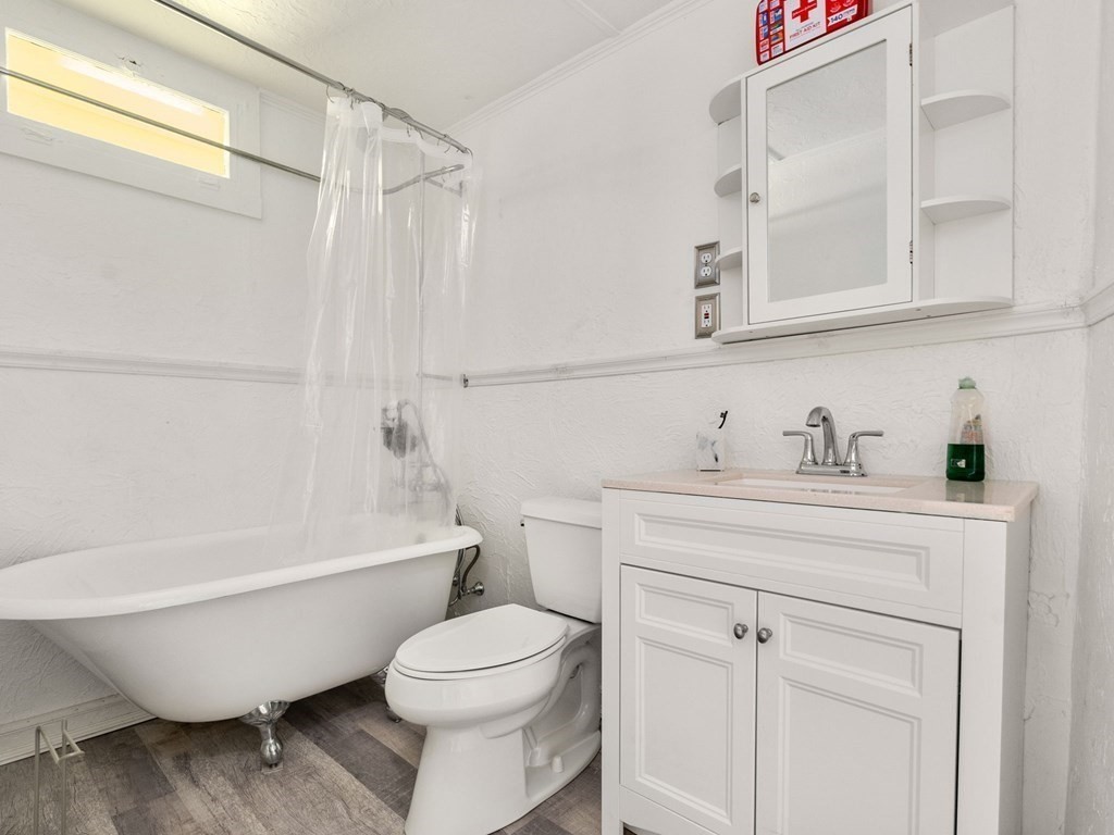 173 School Street Webster, MA 01570 - Photo 10 of 26 a bathroom with a white toilet sitting next to a bathroom sink and a bathtub