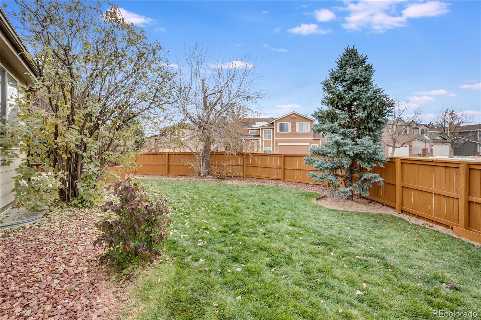 7135 Leopard Drive Lone Tree, CO 80124 - Photo 22 of 47 a view of a backyard with wooden fence