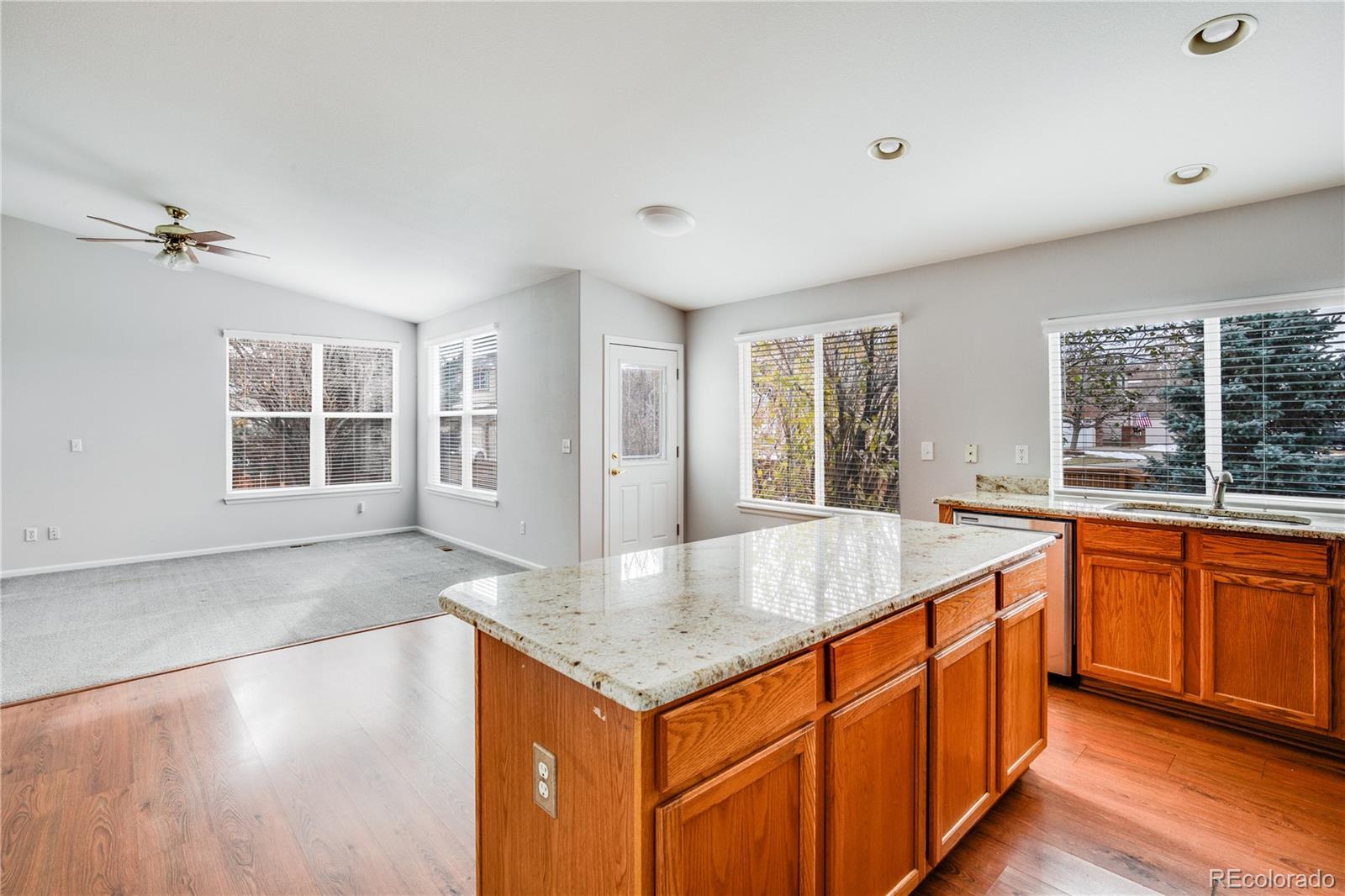 7135 Leopard Drive Lone Tree, CO 80124 - Photo 30 of 47 an open kitchen with granite countertop a sink and dishwasher with wooden floor