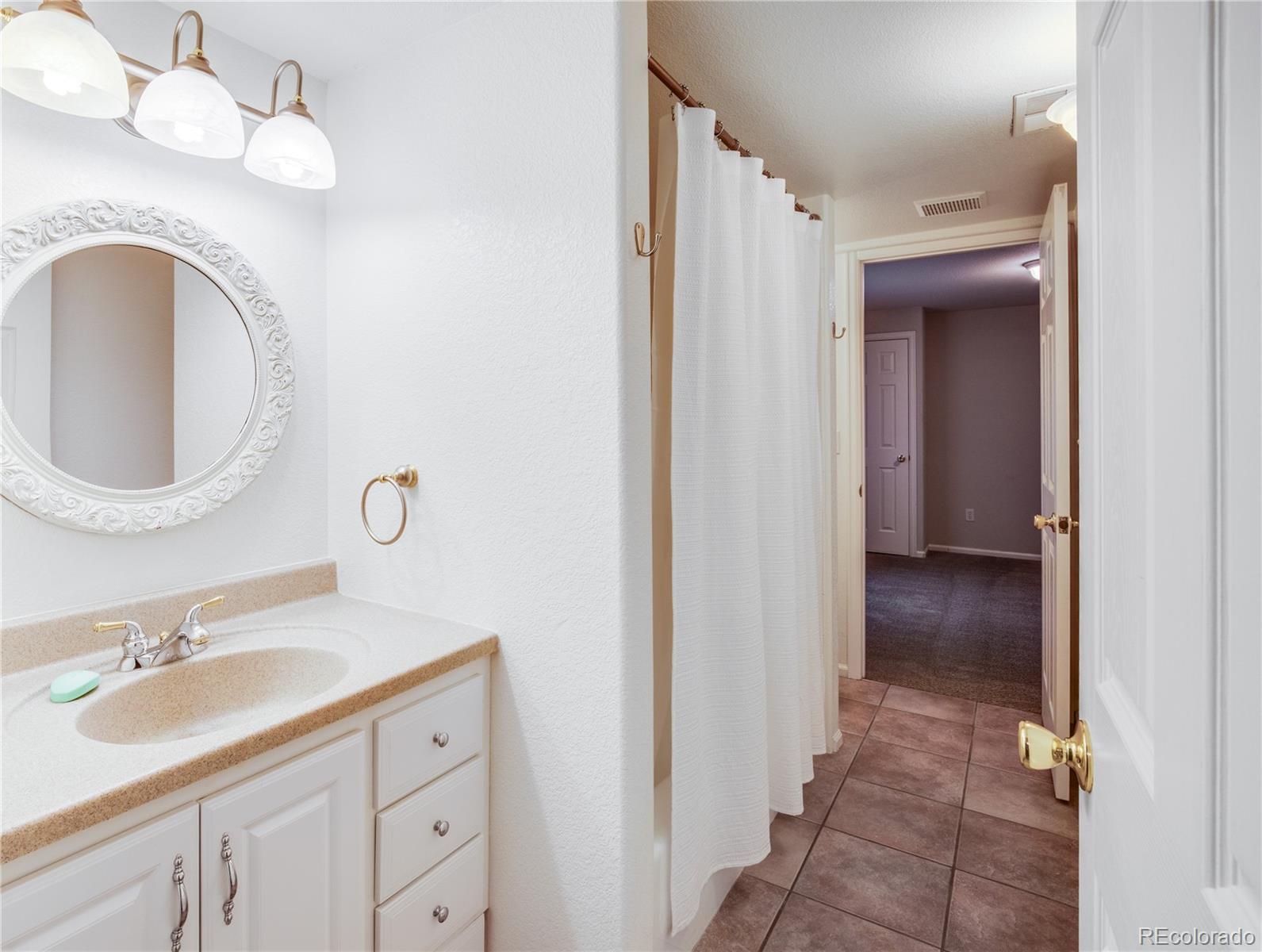 7135 Leopard Drive Lone Tree, CO 80124 - Photo 44 of 47 a bathroom with a sink and a mirror