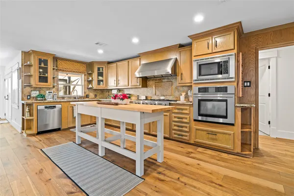 a kitchen with stainless steel appliances a stove top oven and a refrigerator