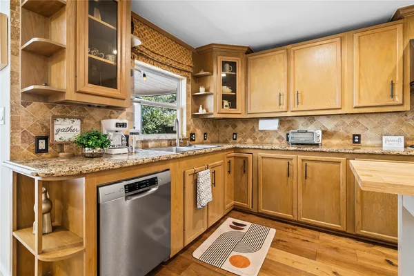a kitchen with stainless steel appliances granite countertop a sink and a cabinets
