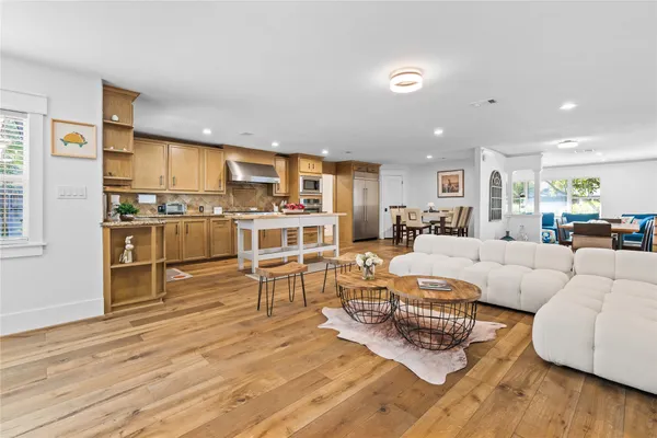 a living room with furniture wooden floor and a large window