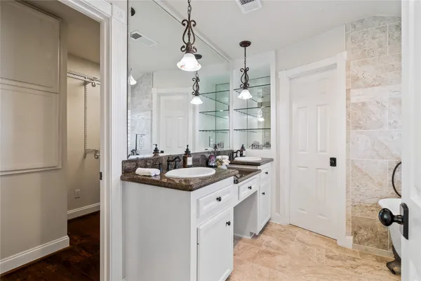 a bathroom with a sink a toilet a mirror and shower