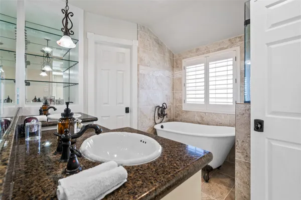 a bath tub sitting next to a blue sink and window