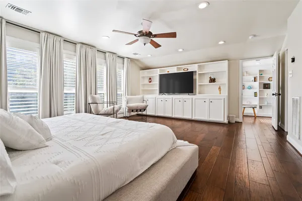 a spacious bedroom with a large bed and a flat screen tv