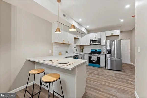 a kitchen with kitchen island a stove a table and chairs