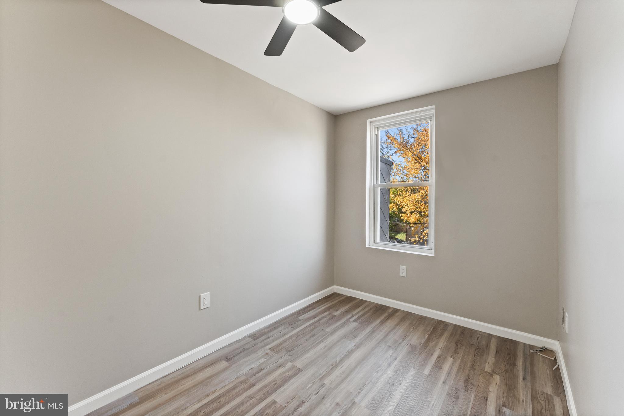 602 Denison Street Baltimore, MD 21229 - Photo 13 of 17 an empty room with a window and wooden floor
