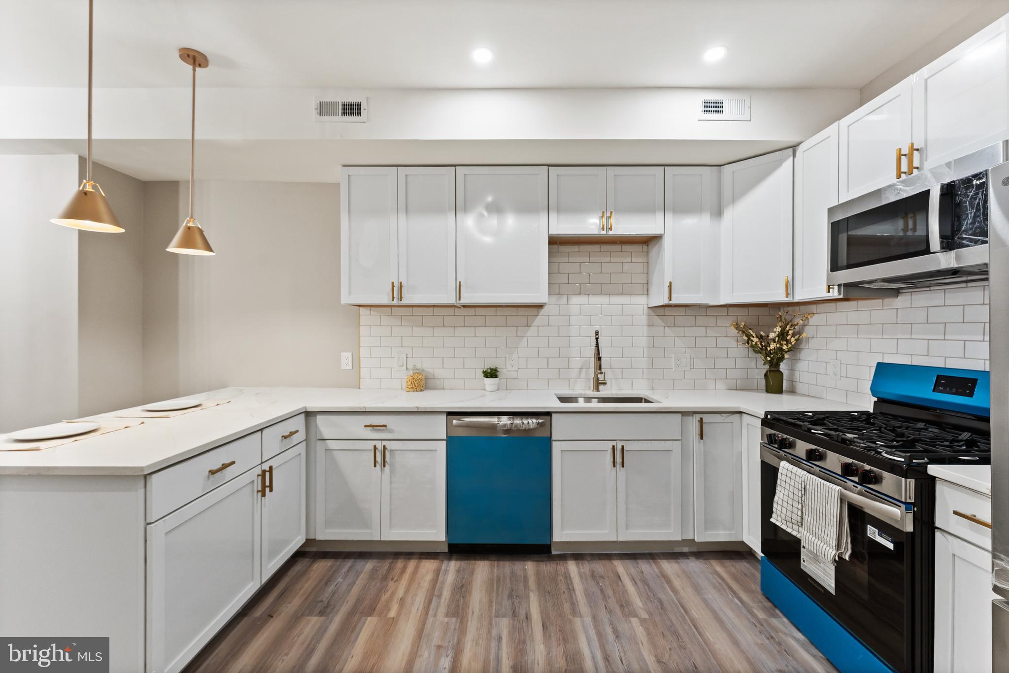602 Denison Street Baltimore, MD 21229 - Photo 6 of 17 a kitchen with a sink stove and microwave