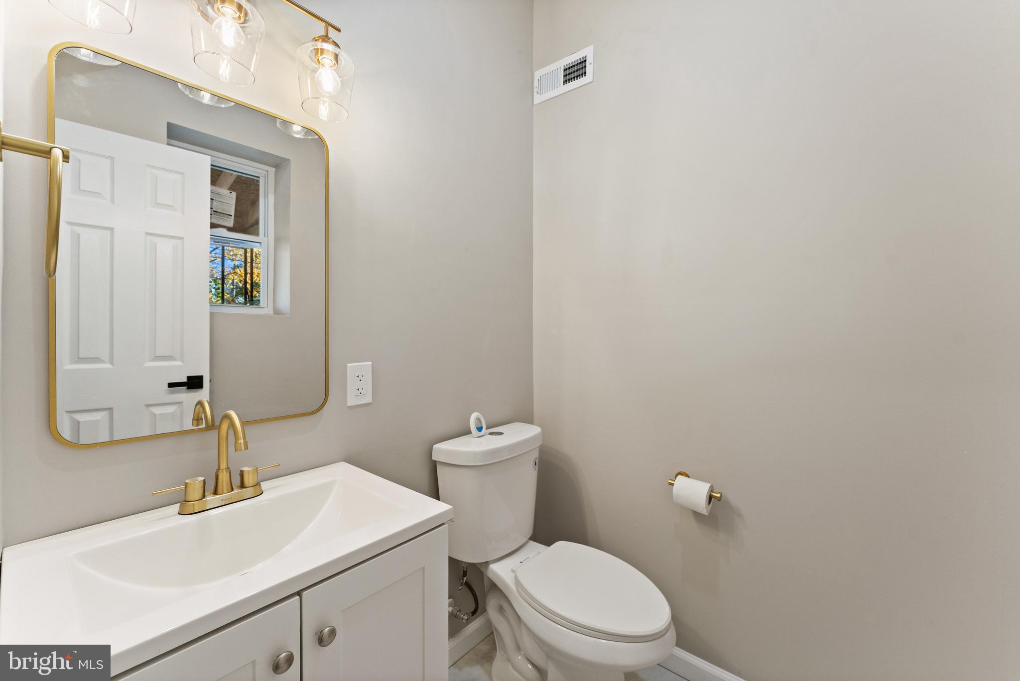 602 Denison Street Baltimore, MD 21229 - Photo 9 of 17 a bathroom with a sink a toilet and mirror