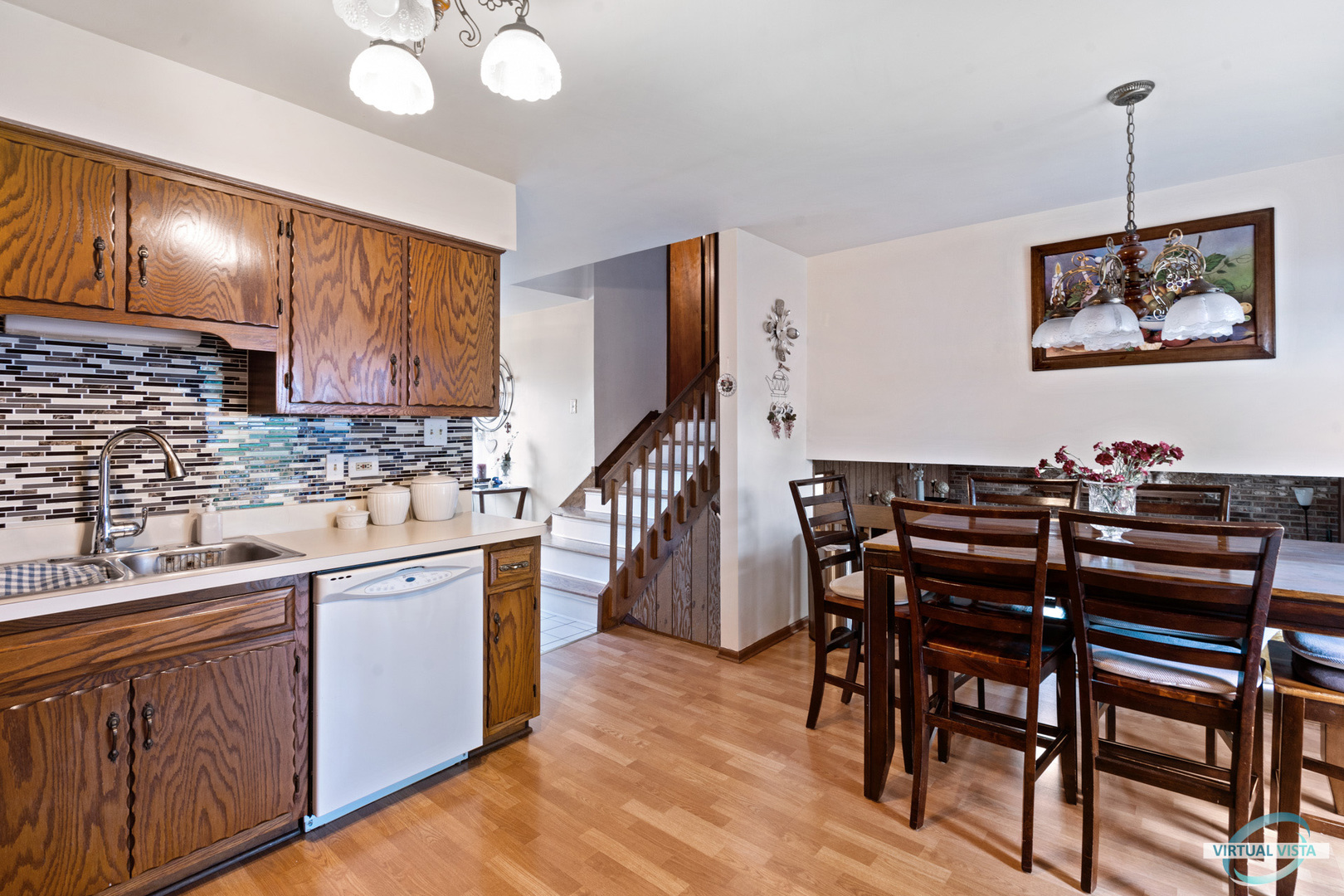 19205 Ada Street Lansing, IL 60438 - Photo 6 of 15 a kitchen with stainless steel appliances kitchen island granite countertop a stove a sink a dining table and chairs with wooden floor