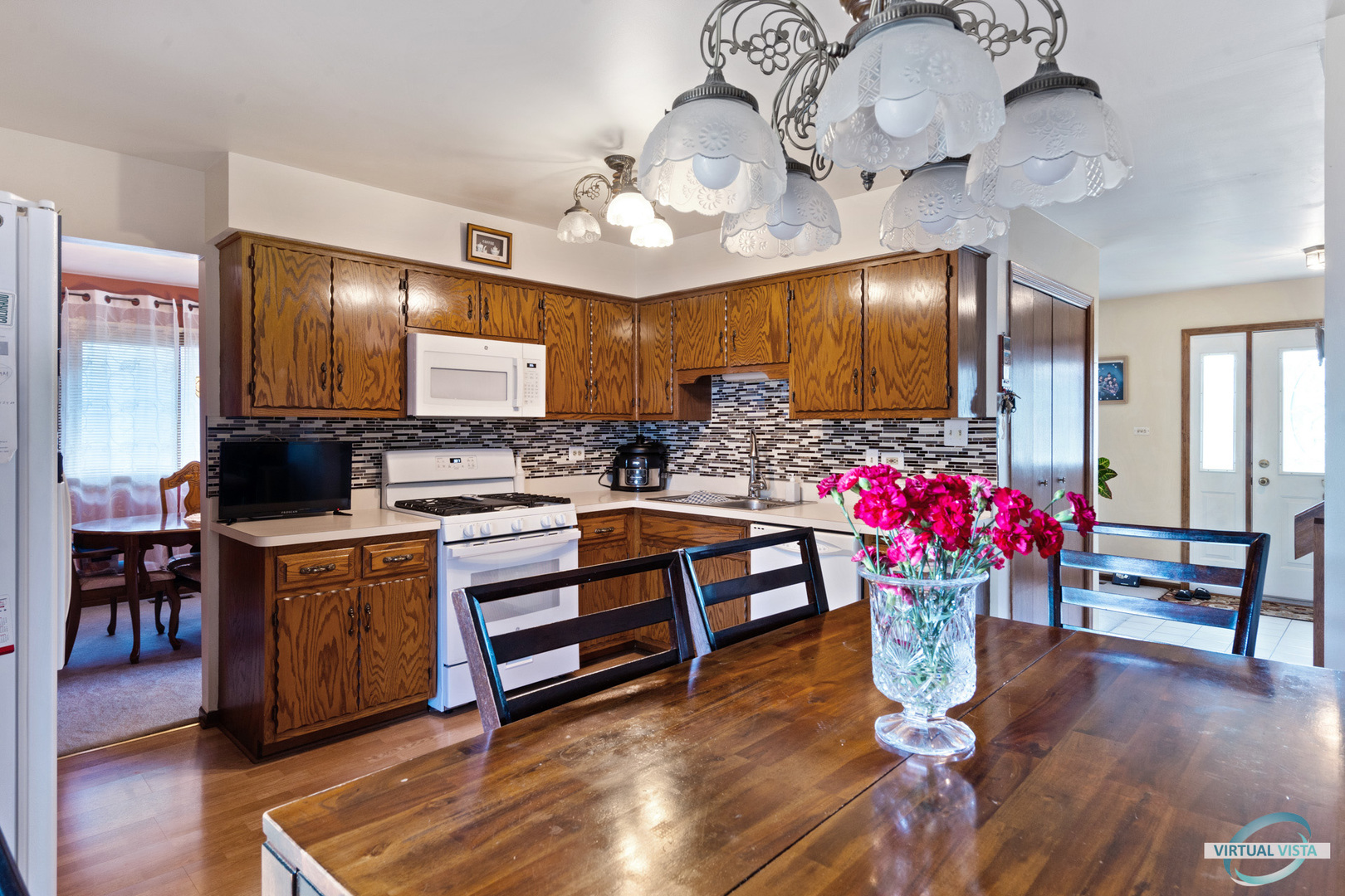 19205 Ada Street Lansing, IL 60438 - Photo 7 of 15 a kitchen with granite countertop a dining table chairs sink and cabinets