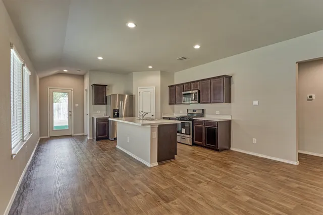 a large kitchen with a sink and a stove top oven