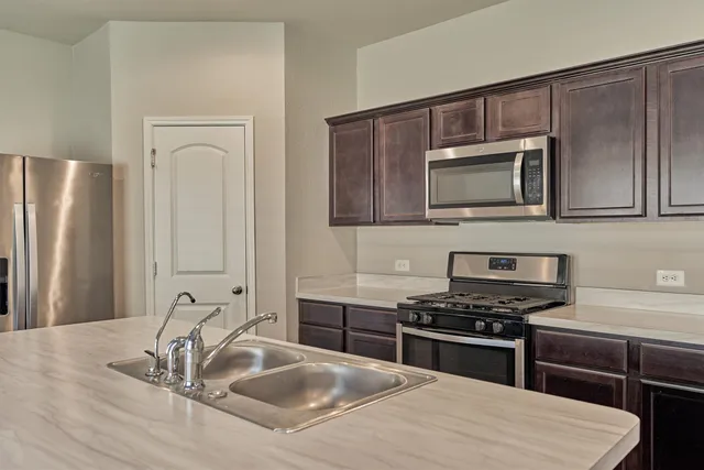 a kitchen with kitchen island a sink stainless steel appliances and cabinets