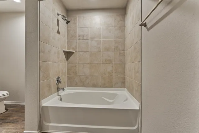 a bath tub sitting next to a white toilet