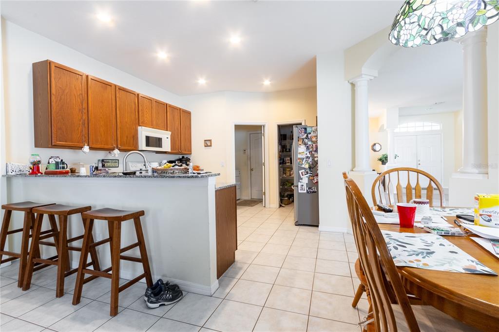 1812 Flower Branch Way Valrico, FL 33594 - Photo 16 of 42 a kitchen with stainless steel appliances kitchen island granite countertop a refrigerator oven a sink dishwasher and white cabinets with wooden floor
