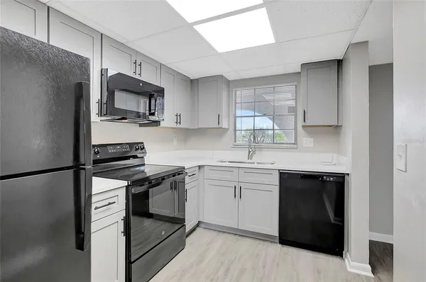 a kitchen with a sink appliances and cabinets