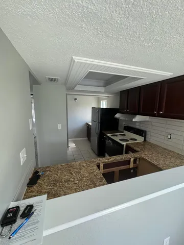 a kitchen with stainless steel appliances granite countertop a sink stove and cabinets