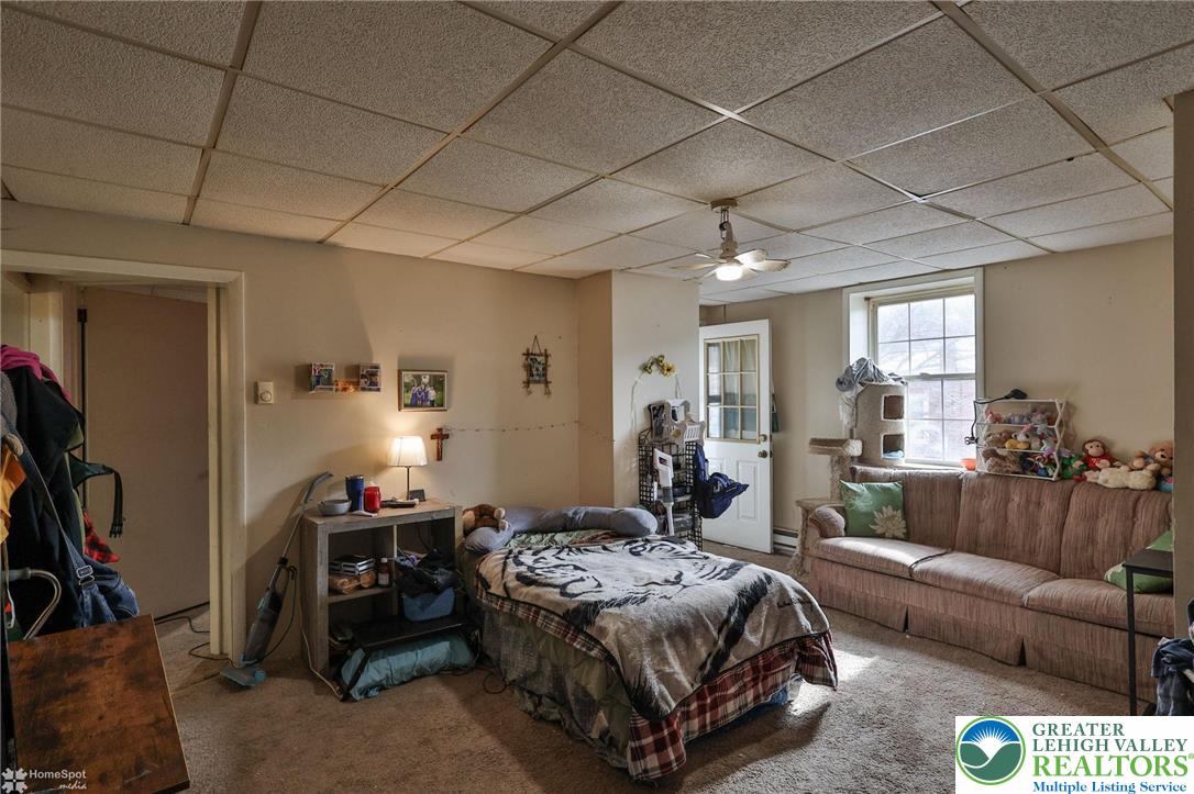 214 West Ridge Street Lansford, PA 18232 - Photo 40 of 52 a spacious bedroom with a bed a couch and a bookshelf