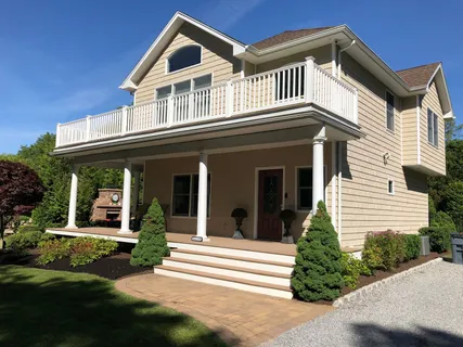 a view of a house with a small yard plants and large tree