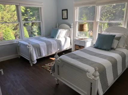 a bedroom with two beds and a large window