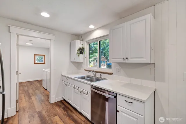 a kitchen with a sink cabinets and wooden floor