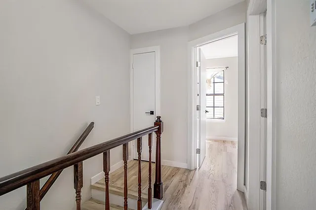 a view of a hallway with wooden floor and entryway
