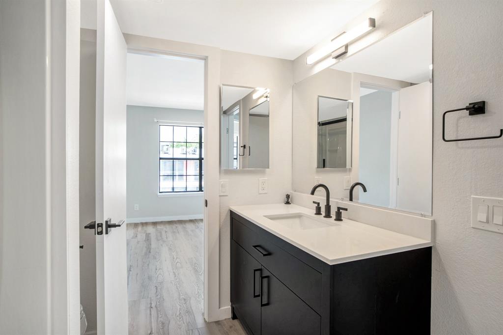 618 West Collins Street Denton, TX 76201 - Photo 19 of 25 Bathroom featuring vanity, light wood-type flooring, and a textured wall