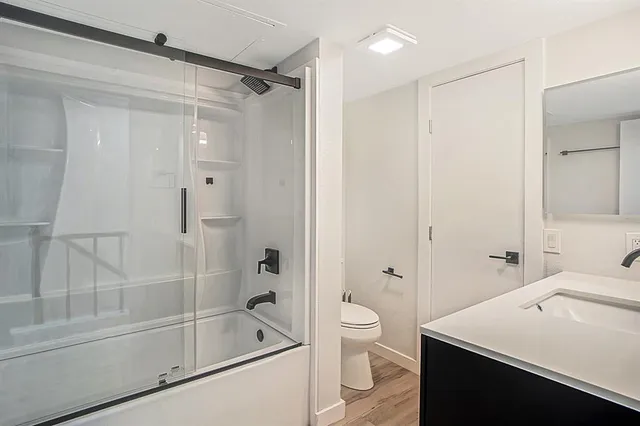 a bathroom with a sink a toilet and shower