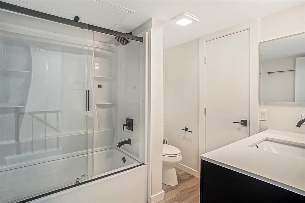 618 West Collins Street Denton, TX 76201 - Photo 4 of 25 Bathroom with bath / shower combo with glass door, vanity, and light wood-style floors