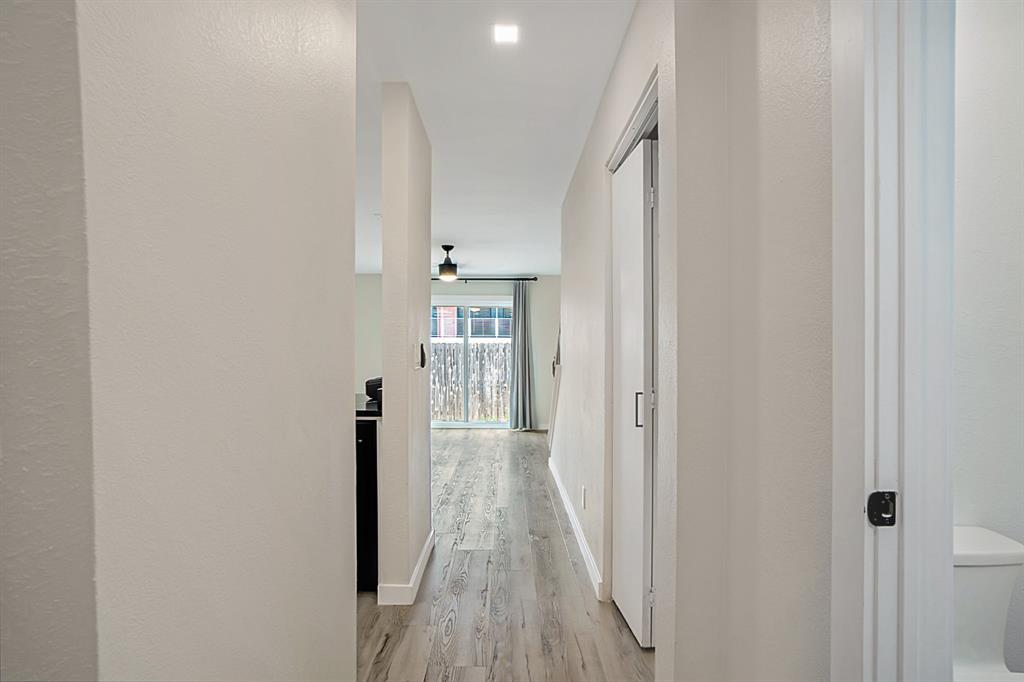 618 West Collins Street Denton, TX 76201 - Photo 6 of 25 Hallway featuring light wood-style flooring and a textured wall