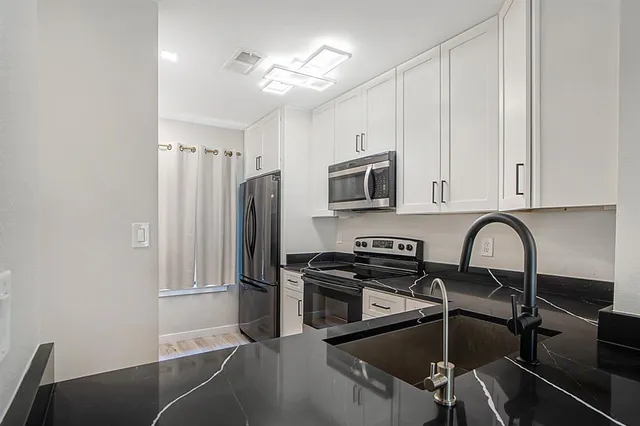 a kitchen with a refrigerator cabinets and a stove top oven
