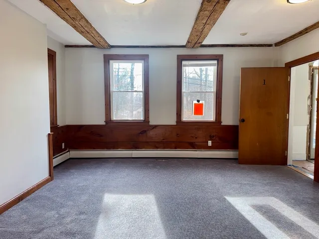 a view of a livingroom with wooden floor and bedroom
