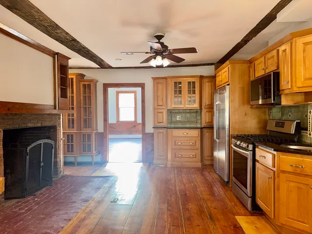 a kitchen with granite countertop wooden floors and stainless steel appliances