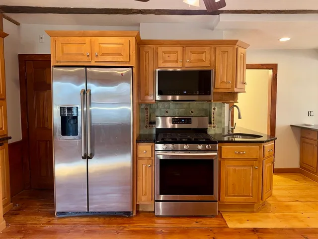 a kitchen with stainless steel appliances granite countertop a stove a refrigerator and a microwave