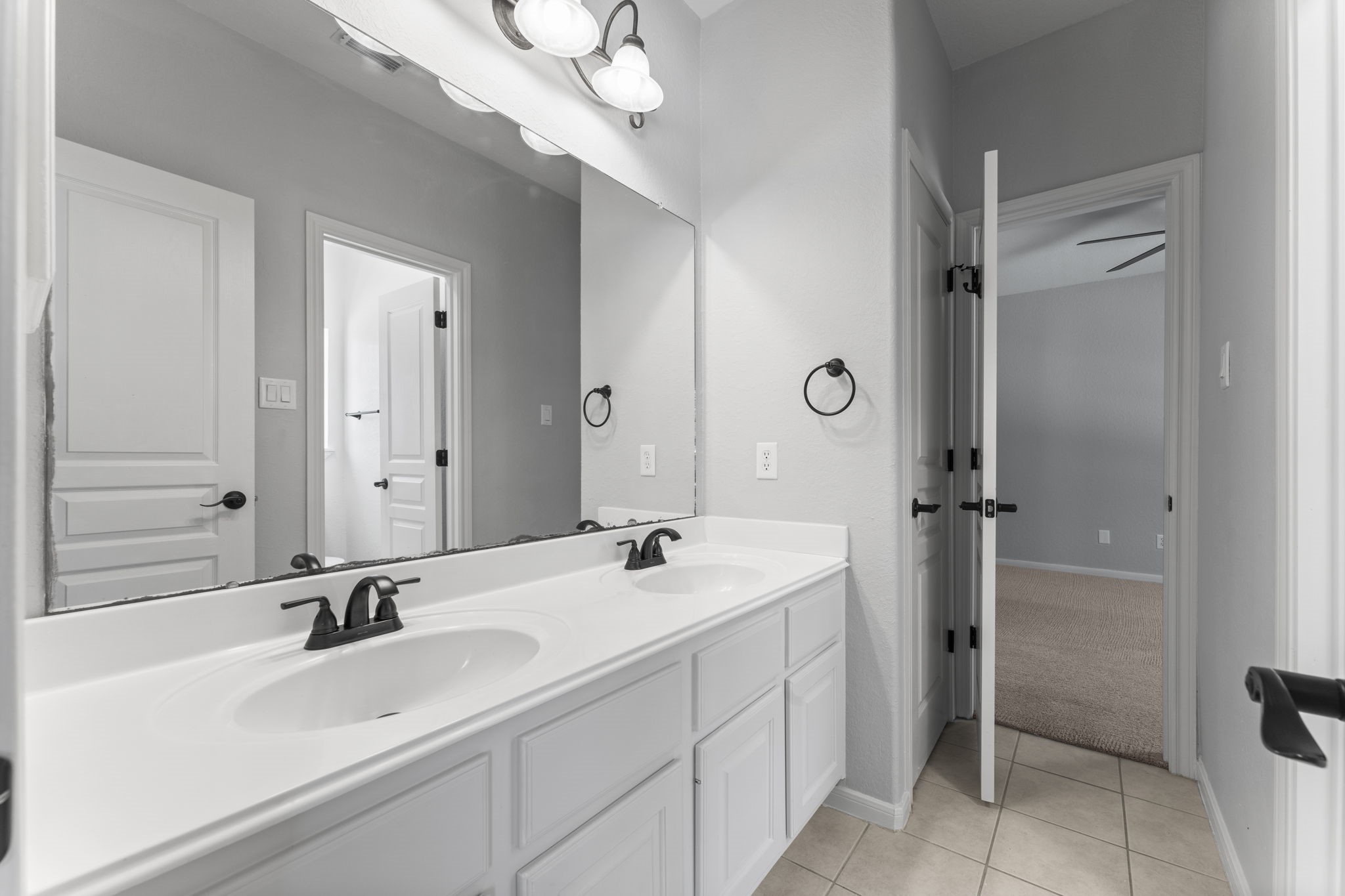 19218 Country Village Drive Spring, TX 77388 - Photo 24 of 35 a bathroom with a double vanity sink a mirror and a shower
