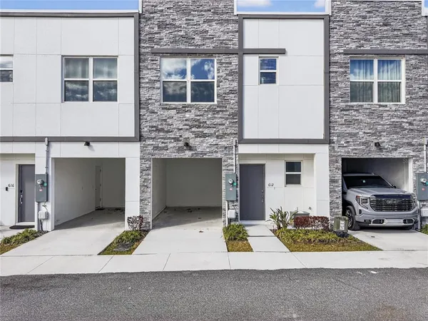 a view of house with yard and car parked