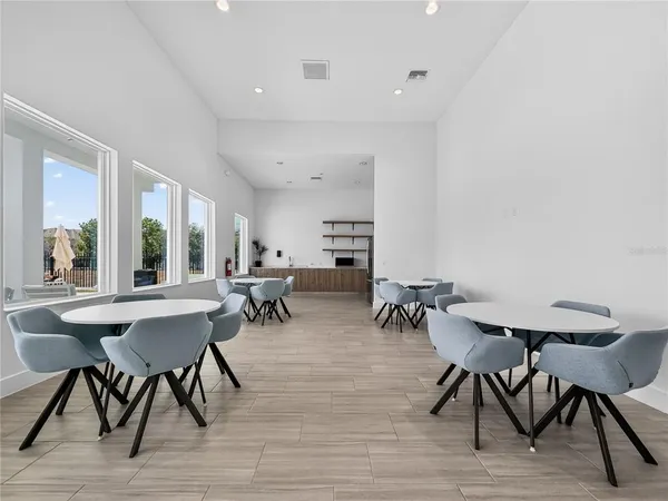 a living room with furniture kitchen view and a large window