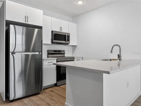 a kitchen with stainless steel appliances a refrigerator microwave and sink